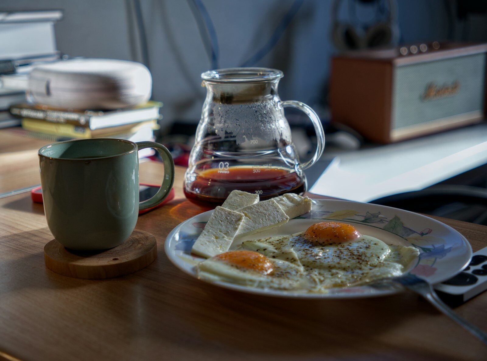 A plate of eggs and a cup of coffee on a table
